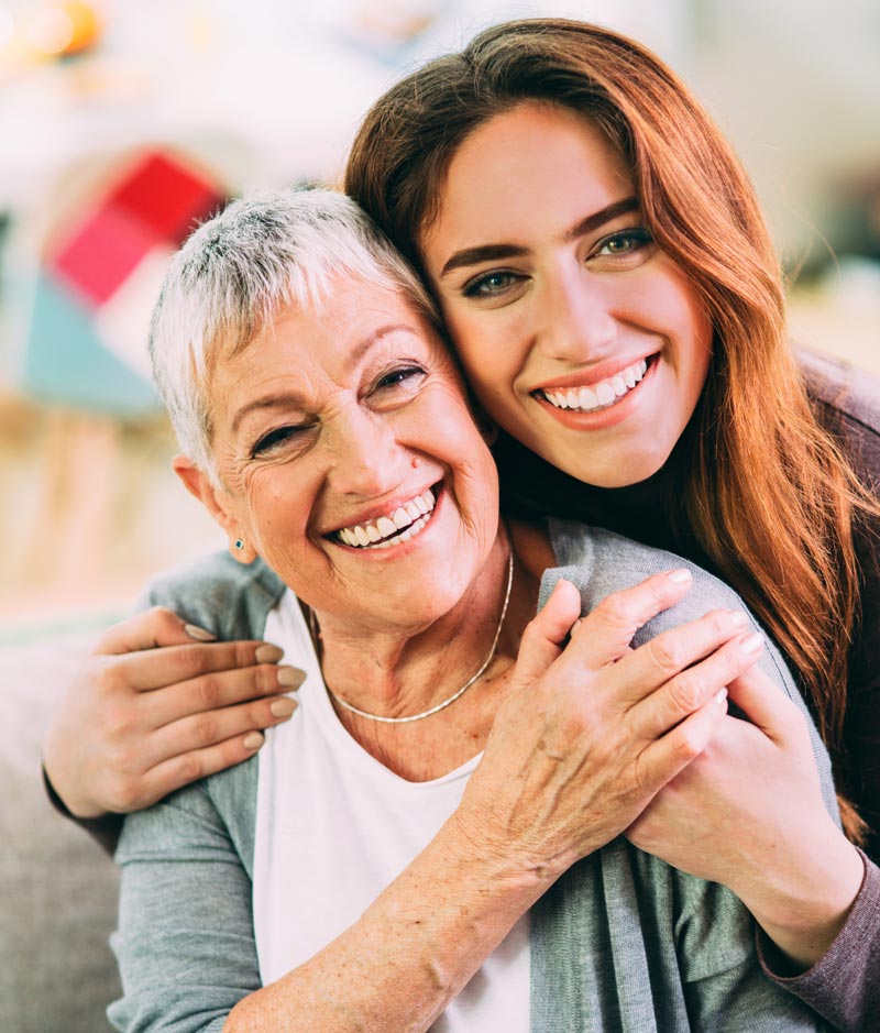 A mother and daughter smiling, illustrating how choosing out-of-network dental care can protect your teeth and wallet, at Living Dental Health in Bend, Oregon.